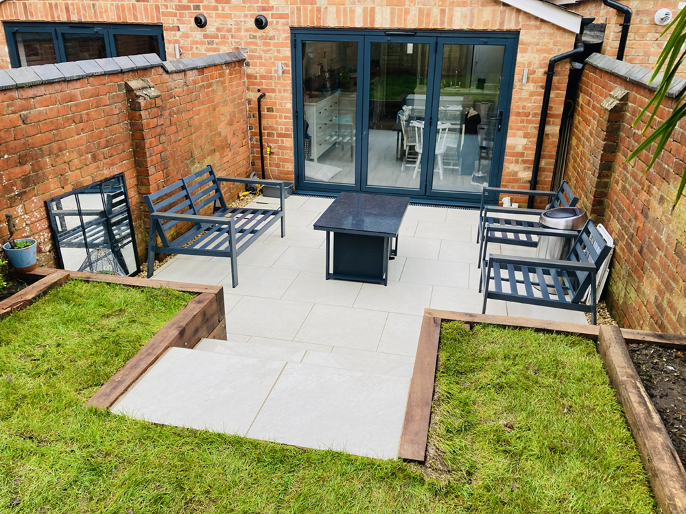 Raised Indian sandstone garden patio with sleeper borders in Sonning